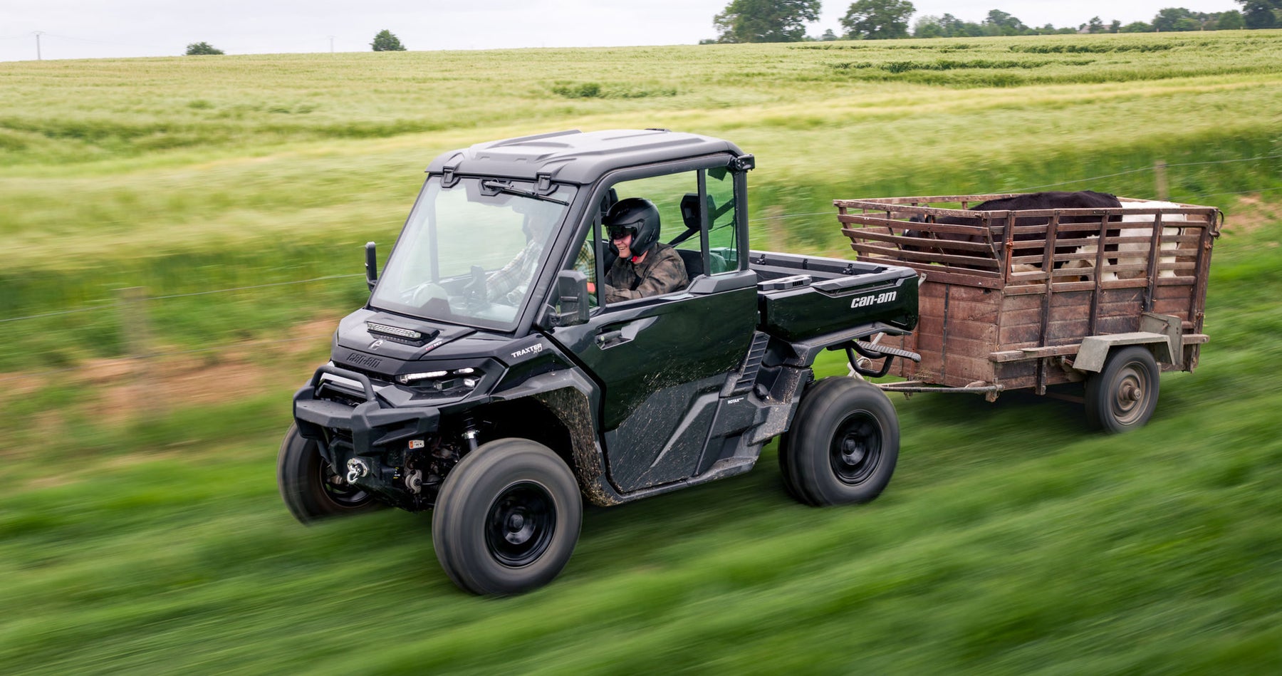 Can-Am Traxter towing a livestock trailer across a field